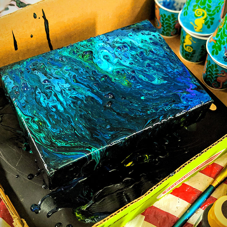 Blue poured acrylic paint on canvas
