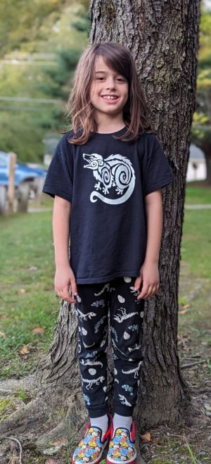 child wearing a screaming possum t-shirt. Shirt is black with a white design of an opossum screaming.